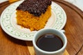 A piece of carrot cake inside a plate with a cup of coffee. Royalty Free Stock Photo