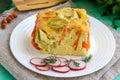 A piece of casserole of vegetables (zucchini, carrots) on a white plate.