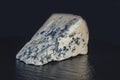 A piece of cheese with blue mould on a black background closeup Royalty Free Stock Photo