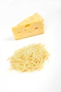 Piece of cheese and heap of grated cheese, isolated on white background.
