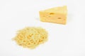 Piece of cheese and heap of grated cheese, isolated on white background.