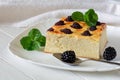 A piece of cheesecake with blackberry berries on a white plate