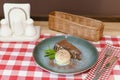 A piece of chocolate brownie pancake cake with vanilla ice-cream and chocolate sauce served on a blue plate. Royalty Free Stock Photo