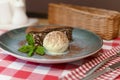 A piece of chocolate brownie pancake cake with vanilla ice-cream and chocolate sauce served on a blue plate. Royalty Free Stock Photo