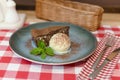 A piece of chocolate brownie pancake cake with vanilla ice-cream and chocolate sauce served on a blue plate. Royalty Free Stock Photo