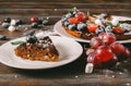 Piece of chocolate cake with blueberries, grapes, mint and powdered sugar on a plate on a wooden Royalty Free Stock Photo