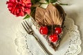 Piece of chocolate cake with cherries and flower China rose on white napkin Royalty Free Stock Photo