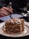 A piece chocolate cake from cookies, poured with chocolate, on a plate in a coffee shop in popular confectionery cafe 1743 in a to