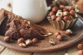 Piece of chocolate cake, hazelnuts and jar with milk Royalty Free Stock Photo