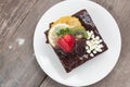 Piece of chocolate cake with icing and fresh berry on wooden background Royalty Free Stock Photo