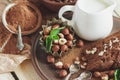 Piece of chocolate cake, mint leaves, hazelnuts and jar with milk Royalty Free Stock Photo