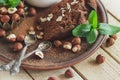Piece of chocolate cake, mint leaves, hazelnuts and jar with milk Royalty Free Stock Photo