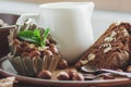 Piece of chocolate cake, mint leaves, hazelnuts and jar with milk Royalty Free Stock Photo