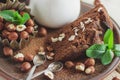 Piece of chocolate cake, mint leaves, hazelnuts, and jar with milk Royalty Free Stock Photo