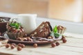 Piece of chocolate cake, mint leaves, hazelnuts and jar with milk Royalty Free Stock Photo