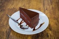 Piece of chocolate cake with spoon on white plate