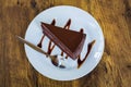 Piece of chocolate cake with spoon on white plate