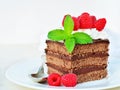 Piece of chocolate cake with whipped cream icing and fresh raspberry Royalty Free Stock Photo