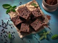 Piece of chocolate fudge on a piece of paper with mint leaves