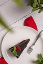 Piece of chocolate Mozart cake and fork on white plate on wooden table Royalty Free Stock Photo