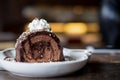 A piece of chocolate roll cake and whipped cream on the top in white ceramics plate and coffee cup on wooden table Royalty Free Stock Photo