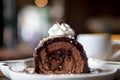 A piece of chocolate roll cake and whipped cream on the top in white ceramics plate and coffee cup on wooden table with blur backg Royalty Free Stock Photo