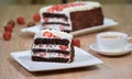 Piece of chocolate strawberries cake on the white plate with a cup of tea Royalty Free Stock Photo