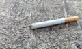a piece of cigarette butt that has not been used up lying on the road Royalty Free Stock Photo