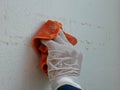 A piece of cloth, soaked with thinner, in a hand of a painter being used to remove sticky rough glue and tape remain on the old