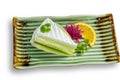 Piece of coconut cake and pandan smell with decorate flowers and orange sliced on beautiful rectangle ceramic plate