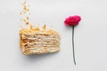 A piece of creamy cake with a rose on a white background. Top view Royalty Free Stock Photo