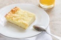 Piece of curd casserole on white plate and glass with smoothie on wooden saw cut. Royalty Free Stock Photo