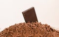 Piece of dark chocolate on heap of grated chocolate Royalty Free Stock Photo
