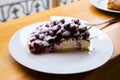 A piece of delicious cherry cake or tart with cream and caster sugar in the white plate Royalty Free Stock Photo