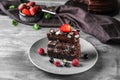 Piece of delicious chocolate cake with berries on plate Royalty Free Stock Photo