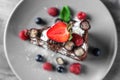 Piece of delicious chocolate cake with berries on plate Royalty Free Stock Photo