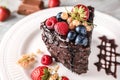Piece of delicious chocolate cake with berries on plate, closeup Royalty Free Stock Photo