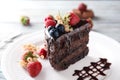 Piece of delicious chocolate cake with berries on plate, closeup Royalty Free Stock Photo