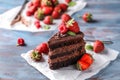 Piece of delicious chocolate cake with berries on wooden table Royalty Free Stock Photo