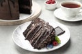 Piece of delicious chocolate cake decorated with fresh berries served on white table Royalty Free Stock Photo