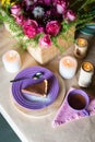 Piece of delicious chocolate mousse cake on colorful plate on wooden table background. Table setting with flowers and candles for Royalty Free Stock Photo