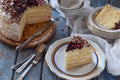 A piece of delicious coconut layer cake - a biscuit and cream on coconut cream, decorated with grated chocolate and candied rose