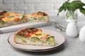 Piece of delicious homemade quiche with salmon and broccoli on light grey table Royalty Free Stock Photo