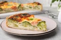 Piece of delicious homemade quiche with salmon and broccoli on light grey table, closeup Royalty Free Stock Photo