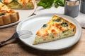 Piece of delicious homemade salmon quiche with broccoli and fork on wooden table Royalty Free Stock Photo