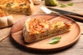 Piece of delicious homemade vegetable quiche on wooden plate, closeup Royalty Free Stock Photo