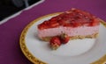 A piece of delicious strawberry cake with jello and strawberries lying on a beautiful plate, top view