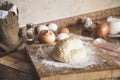 Piece of dough lies on board of flour