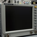 A piece of electronic test equipment resembling an oscilloscope with a gray casing Royalty Free Stock Photo