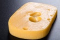 Piece of emmental cheese on black background